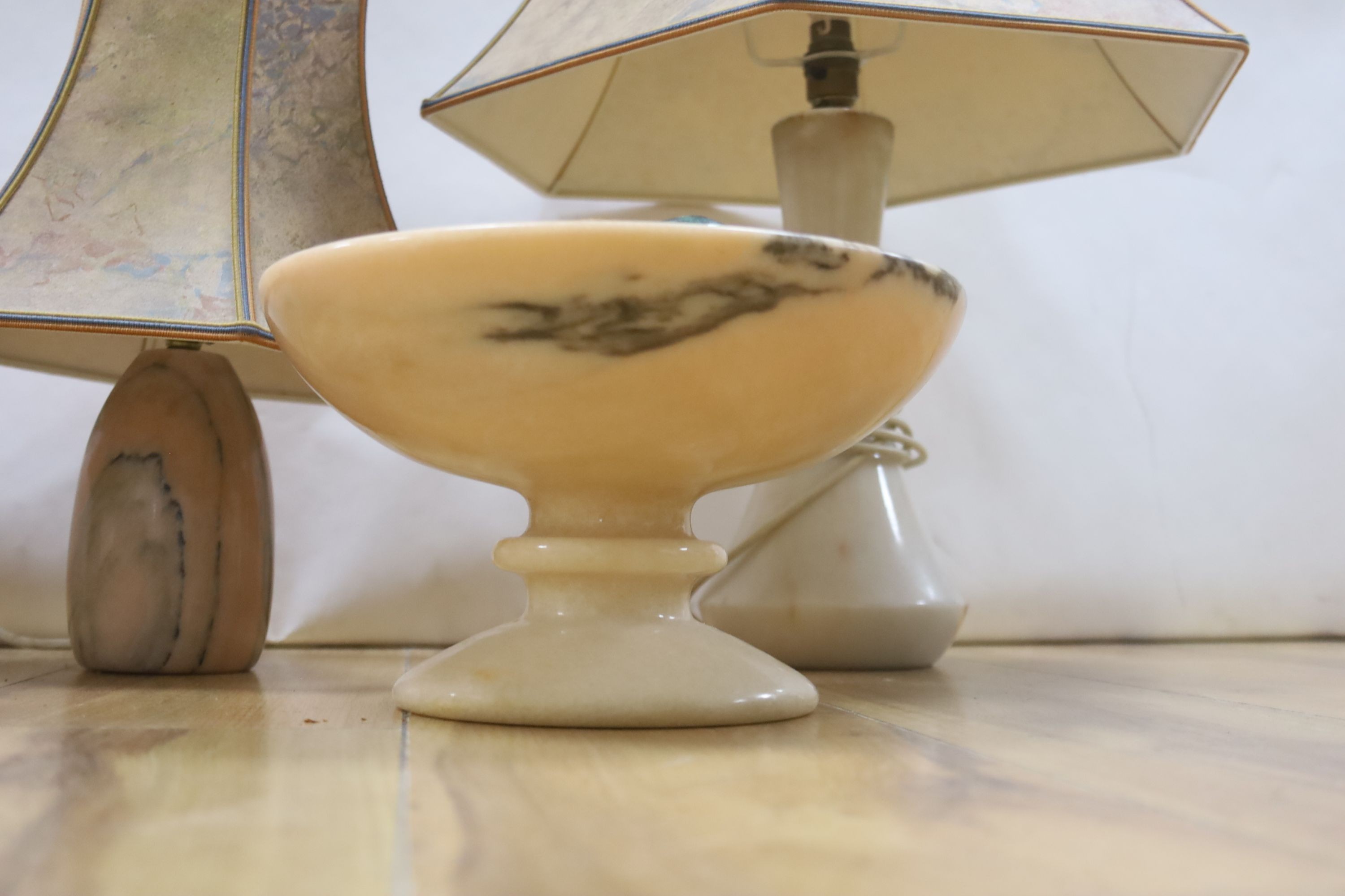 A collection polished stone eggs, dishes and three table lamps and shades.